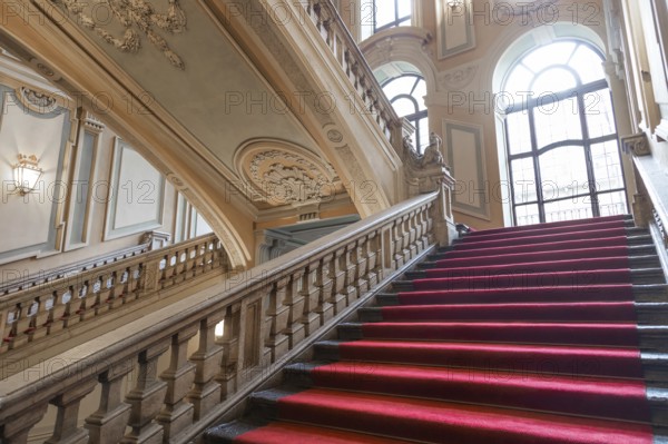 Turin, Italy, January 2023: Palazzo Barolo staircase. Luxury palace with old baroque interior and red carpet, Europe