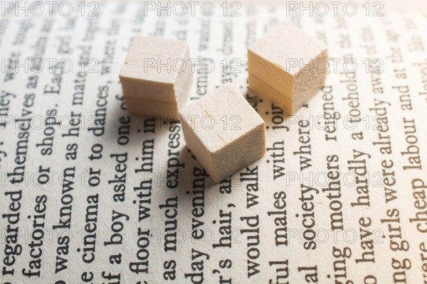 Wooden toy cubes placed on a book page in English
