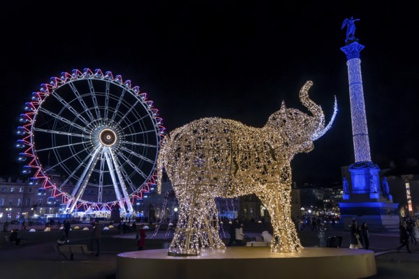 Schlossplatz decorated for Christmas in the evening, with illuminated figure of an elephant and in the background the Jubilee Column decorated with lights and the Ferris wheel decorated with lights, Stuttgart, Baden-Württemberg, Germany, Europe