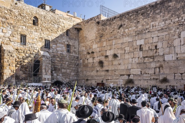 Jerusalem. Jews praying wrapped in festive white Talit. Exciting ceremony at the Western Wall of the Temple. The blessing of the Cohanim. The concept of pilgrimage, religious and photo tourism