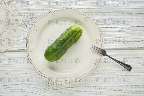 Cucumber full in white plate minimalist concept of raw vegetarian food