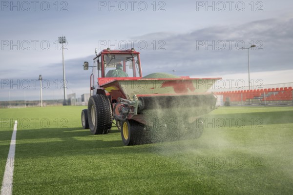 Pouring infill granules in to a football pitch with artificial grass in Lubin, Poland, Europe
