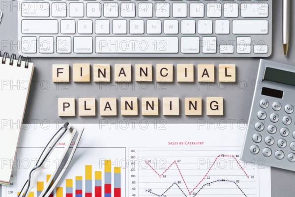 Financial planning concept with letters on cubes. Still life of office workplace. Flat lay grey surface with computer keyboard, calculator and analytic report. Company development and consulting