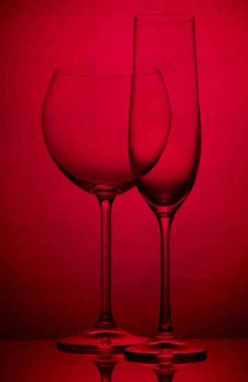 Two empty wineglasses on a red background
