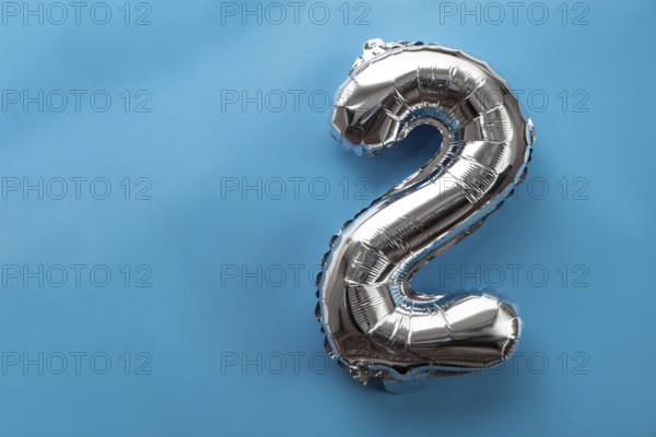 2 two metallic balloon isolated on blue background. Greeting card silver foil balloon number Happy birthday holiday concept. Copy space for text. Celebration party congratulation decoration