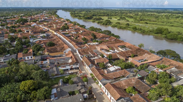 Aerial view of the historic town Santa Cruz de Mompox in sunlight with river and green sourrounding, World Heritage