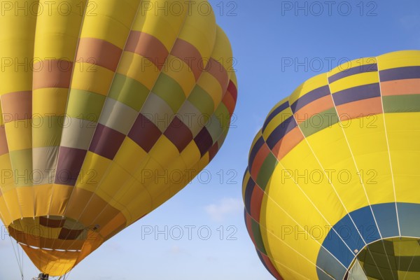 Colorful yellow and red hot air balloons over blue sky in California
