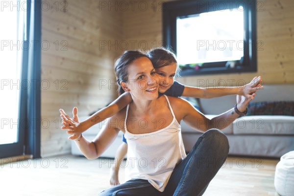Young family with a girl, spending time at home on the weekends. Loving family resting on the couch, playing, watching television