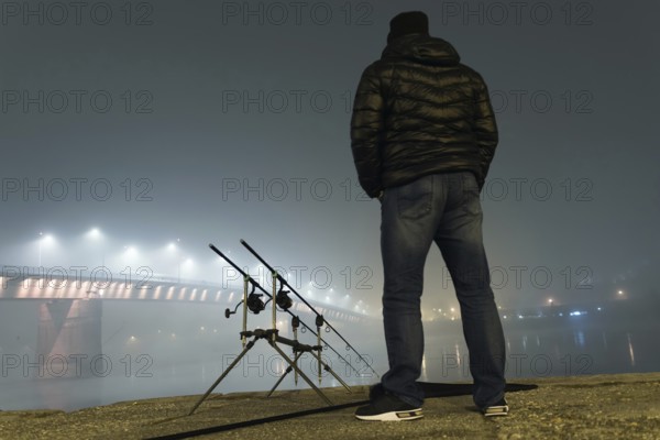 Night Fishing Urban Edition. Fisherman in Foggy night. Night Fishing, Carp Rods, Night reflection. City lights
