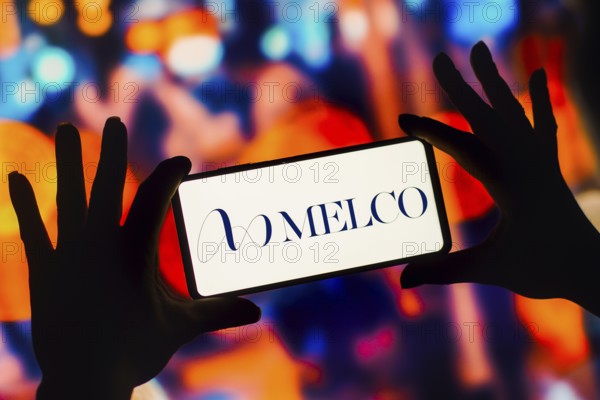 In this photo illustration, the Melco Resorts and Entertainment Limited logo is displayed on a smartphone mobile screen