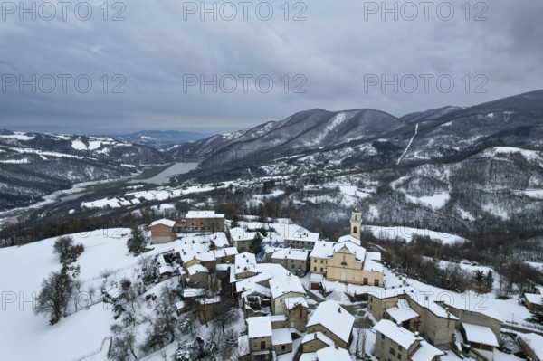 Aerial view of vezzolacca, a small village in the ligurian apennines, covered by snow in winter
