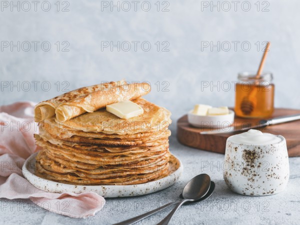 Stack of traditional russian pancakes blini on gray background with copy space. Homemade russian thin pancakes blini. Russian food, russian kitchen