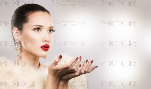 Upscale woman wearing gold jewellery and red lipstick on light background, Toronto, Canada, North America