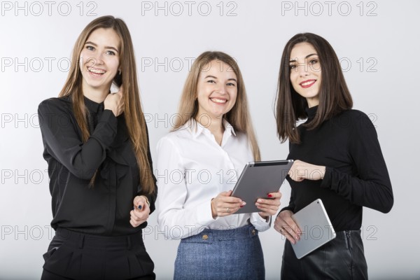 Three smiling business women standing in a row isolated on white background. Business Group people. Happy Business Team. Businesspeople Isolated On White Background