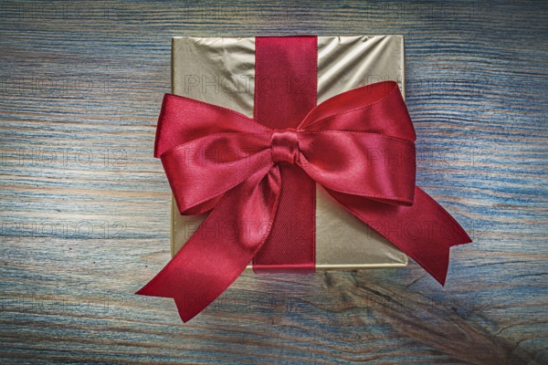 Present box with red tape on vintage wooden board holidays concept