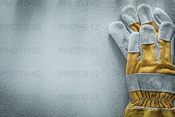 Pair of protective gloves on concrete background copy space
