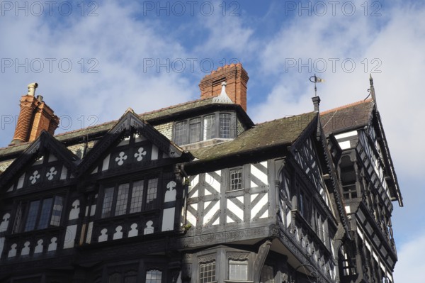 Typical large old half timbered tudor building in Chester city centre with overhanging bays and brick chimneys