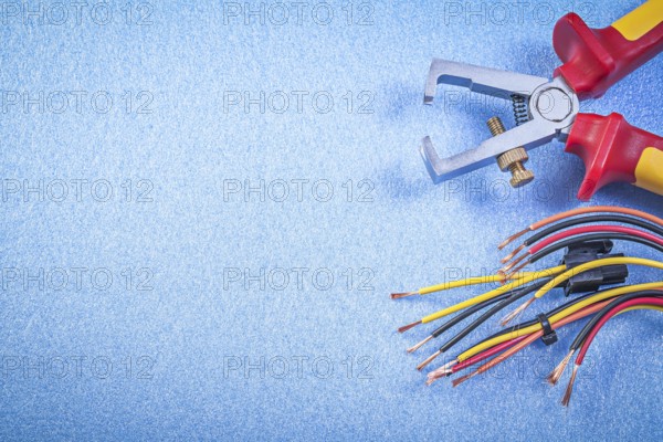 Insulated wire strippers electrical cables on blue background copy space electricity concept