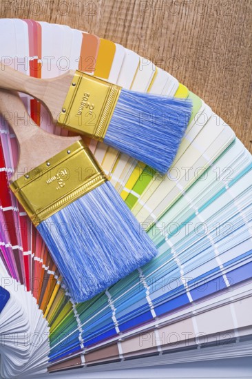 Two paintbrushes on color palette and wooden board