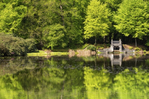Lake with artificial waterfall in the royal palace park Kroondomein in the Dutch city Apeldoorn
