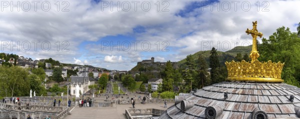 Lourdes, France, 17 April, 2024: view of the town of Lourdes with the hilltop castle and the cupola of the church and sanctuary in the foreground, Europe