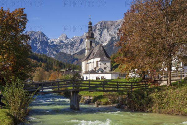Parish church of St. Sebastian in autumn with the river Ramsauer Ache, behind mountains of the Reiteralpe, Ramsau, Berchtesgaden, Berchtesgadener Land, Upper Bavaria, Bavaria, Germany, Europe