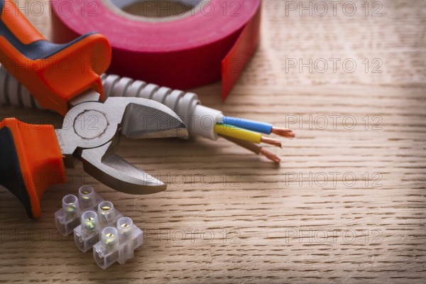 Nippers insulating tape and terminal blocks for electric cables on wooden board