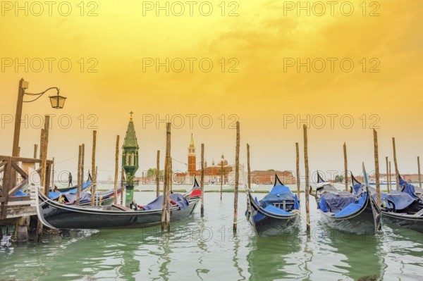 Gondolas near Saint Mark Square (Piazza San Marco) and church of San Giorgio di Maggiore in the background, in Venice, Italy, at sunrise, Europe