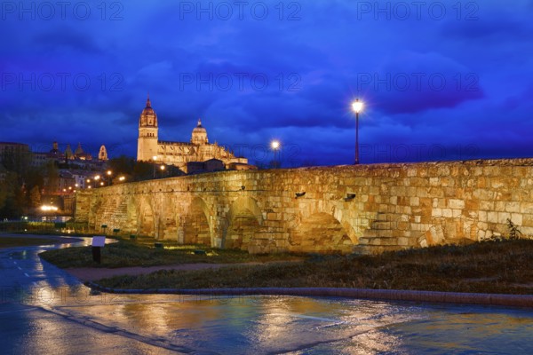 Salamanca skyline sunset and roman bridge over Tormes river in Spain