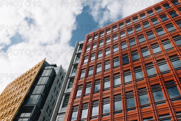 London, UK, August 27, 2023: Low angle view of modern and colorful apartment and office buildings in the City of London. Central Saint Giles in the West End. View against blue sky with white clouds with space for copy