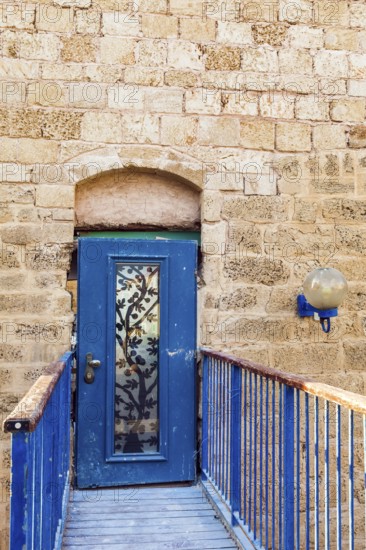 Doors bound by metal bars. Sunset. Old Yaffo - one of the most ancient cities of the world. Warm summer evening. Century masonry walls. Concept active, informative and photo of tourism