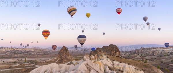 Flying hot air balloons and rock landscape at sunrise time in Goreme, Cappadocia, Turkey, Asia