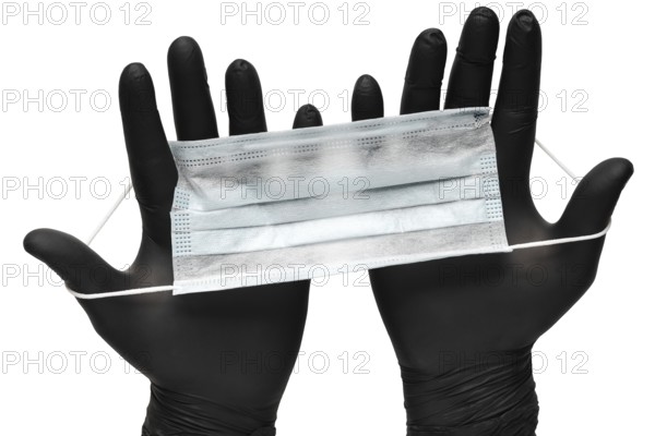 Medical man holds antivirus face mask in hands in black medical gloves. Isolated on white background. Pandemic insurance, airborne diseases, SARS, grippe. Medical masks for human cover nose and mouth
