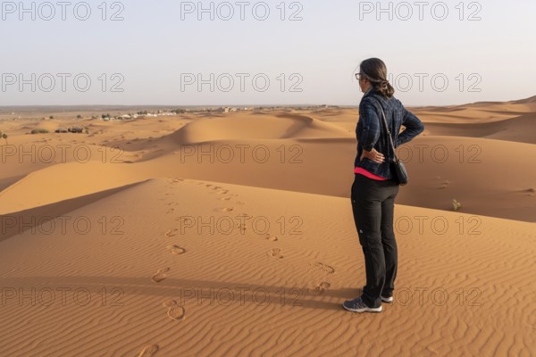A person walking through the Erg Chebbi desert in the African Sahara, Morocco, Africa