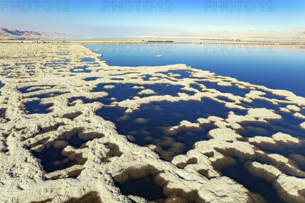 Israel. Dead Sea. The drainless salt lake in the Middle East, the saltiest lake in the world. On the surface of the water, the evaporated salt forms bizarre crystal shapes. The picture was taken by a drone from a aerial view