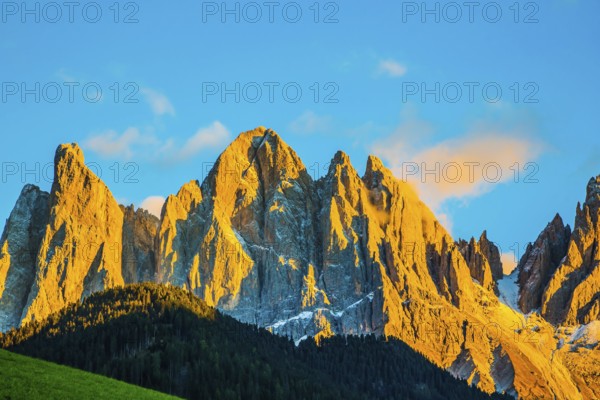 The Dolomites, Tirol. Magnificent serrated cliffs illuminate the summer sunset. The concept of eco-tourism in Alpine meadows
