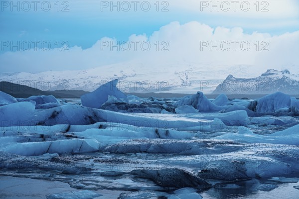 Expansive view of blue icebergs against a wide, frozen skyline in the arctic region, iceberg Iceland, glacier, snow, ice rock, ice diamont, glacier lagoon, nature, snow, diamont beach, Iceland, Europe