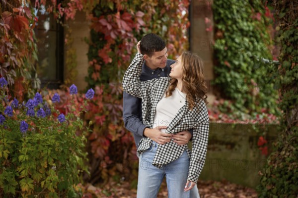 Young Cute Female Hugs Boyfriend. In Autumn Outdoor. Lovers Walking in Park. Attractive Funny Couple. Lovestory in Forest. Man and Woman. Cute Lovers in the Park. Family Concept. Happy Couple