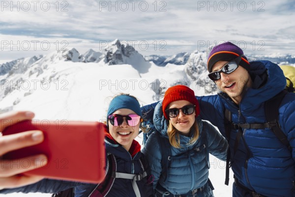 Mountaineer backcountry ski touring in the mountains. Ski touring in high alpine landscape with snowy trees. Adventure winter extreme sport.