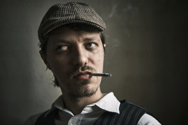 Young guy smoking cigarette, blows smoke, dressed in a retro style, in a beret, cinematic shot, big closeup