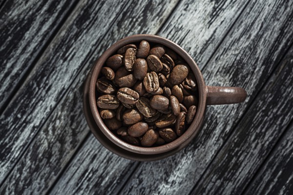 Roasted Coffee Beans In Cup On Wooden Background