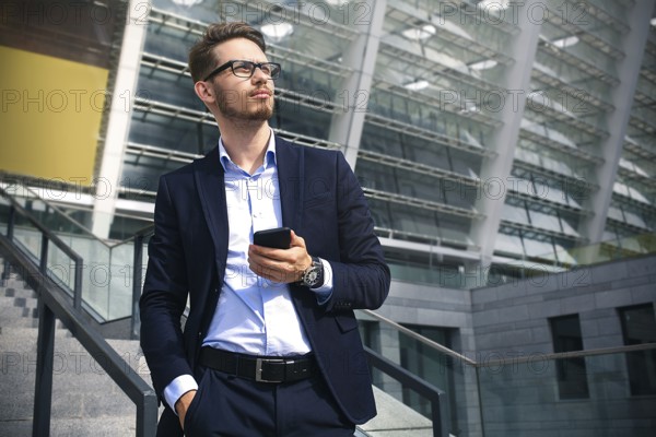 Handsome successful businessman in elegant suit outdoors walking on street in the city