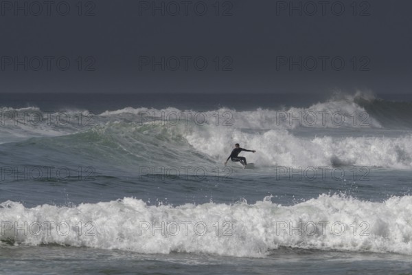 Sidi Ifni, Morocco, 17 March, 2024: man surfing a large wave off the coast of southern Morocco in Sidi Ifni, Africa