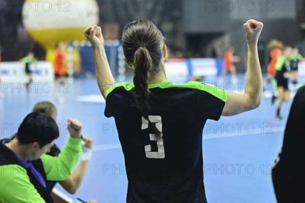 Woman player's back handball match in the background