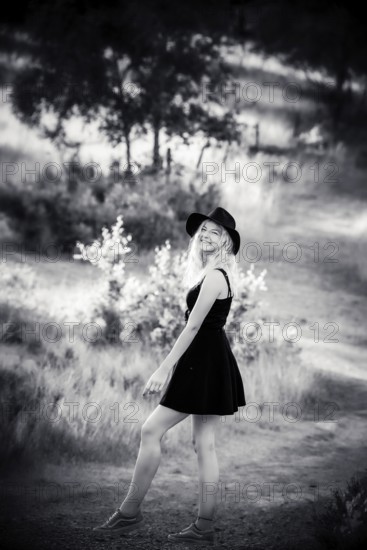 Young blonde woman with black dress in black and white, summertime