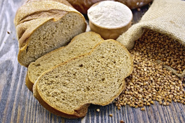 Slices of buckwheat bread, a bag of buckwheat, buckwheat flour in a bowl on a wooden boards background