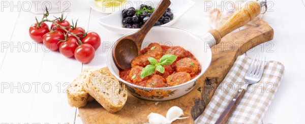 Baked mini meatballs in tomato sauce with basil