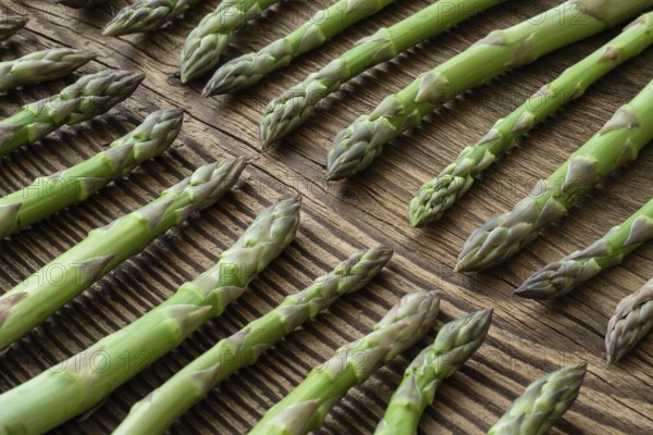 Fresh raw garden asparagus on rustic wooden table background