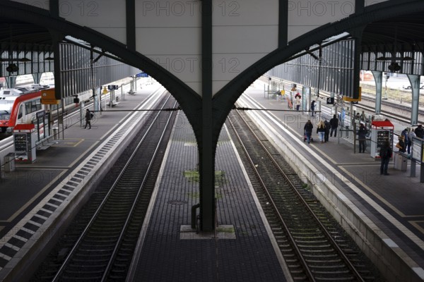 Darmstadt, Germany - November 25, 2017: The roof vault supported by a steel girder and the railway tracks of Darmstadt Central Station with passengers on 25 November 2017 in Darmstadt, Germany, Europe