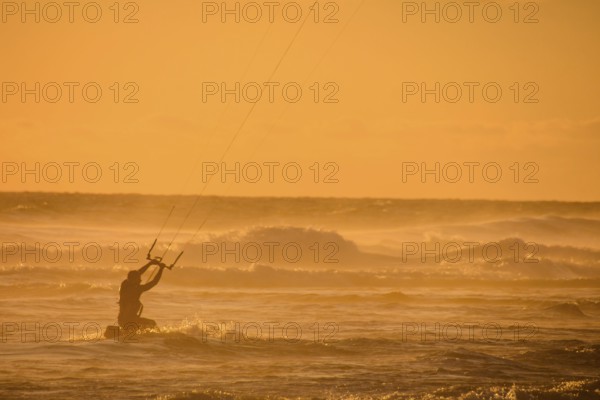 Single surfer at sunset on a calm ocean